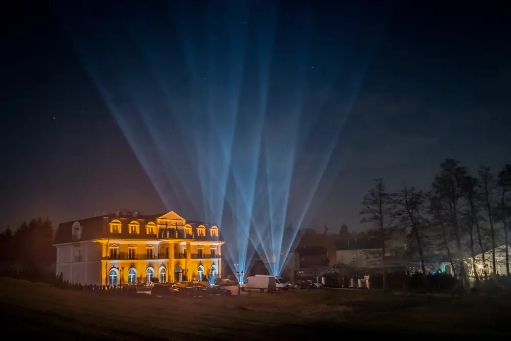 Pałac nocą z wiązkami świateł skierowanymi w niebo